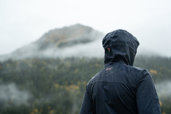 A person wearing a navy rain jacket