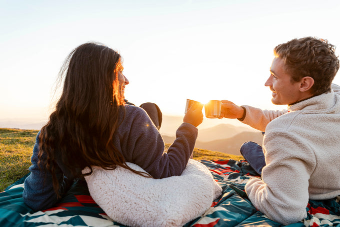 Couple enjoying hot drinks at sunset