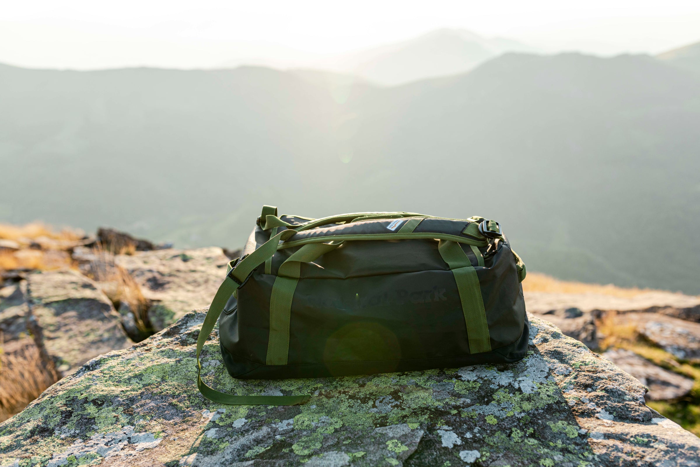 Natural Park duffle bag on a mountain rock at sunrise