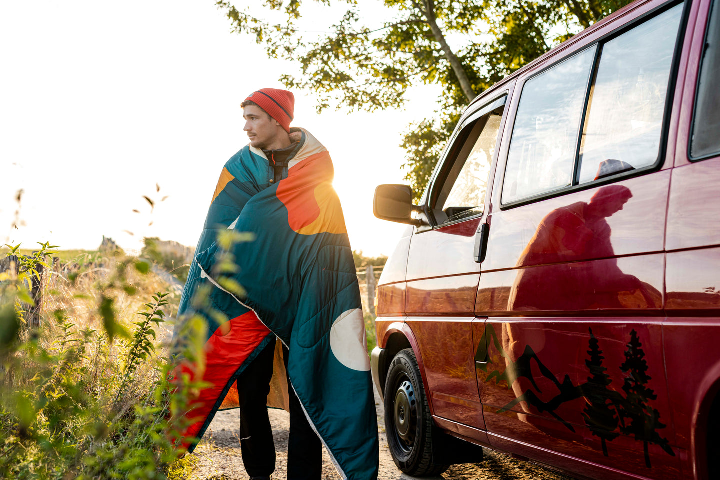 Person wrapped in a Natural Park blanket wearing a beanie