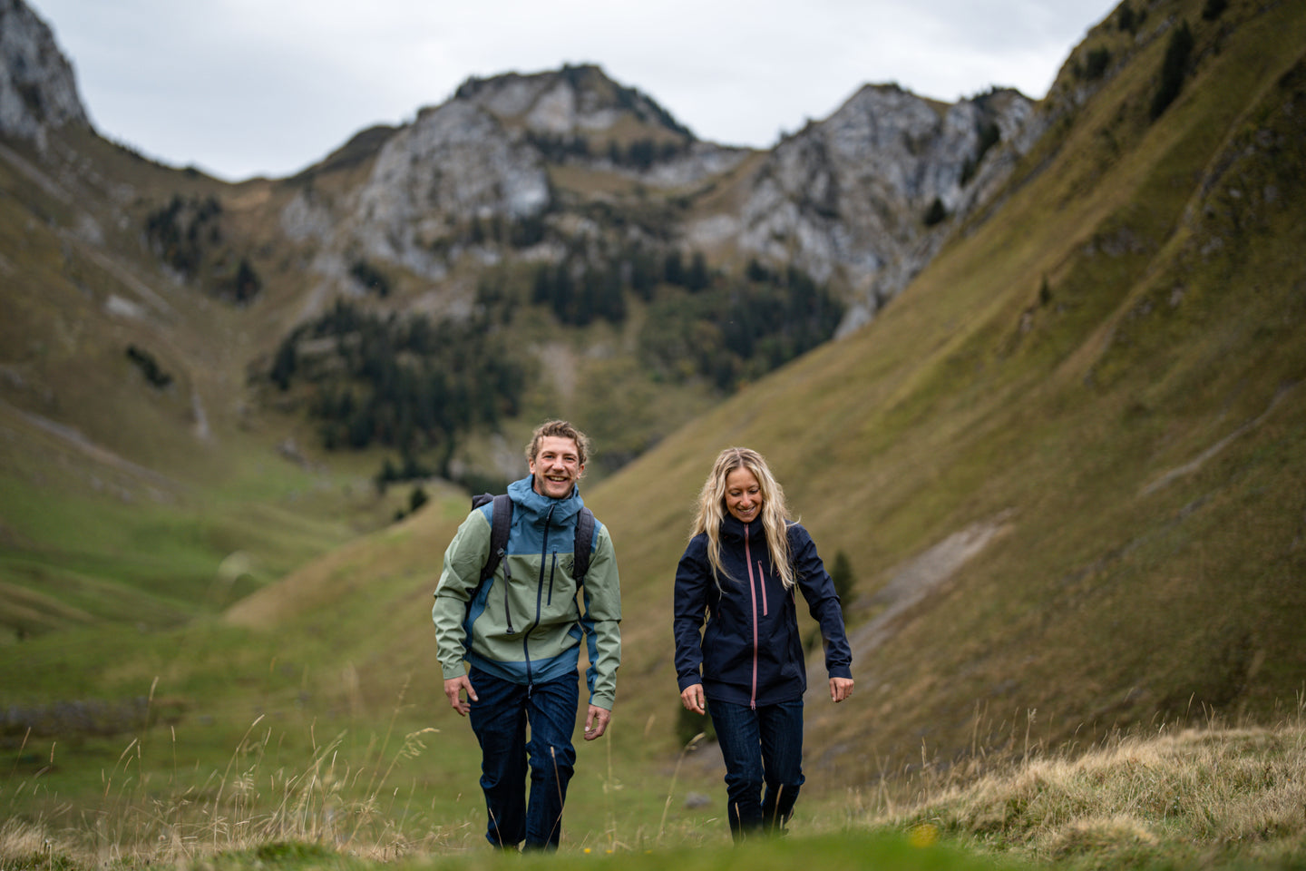 Man and woman hiking in the mountains wearing waterproof jackets