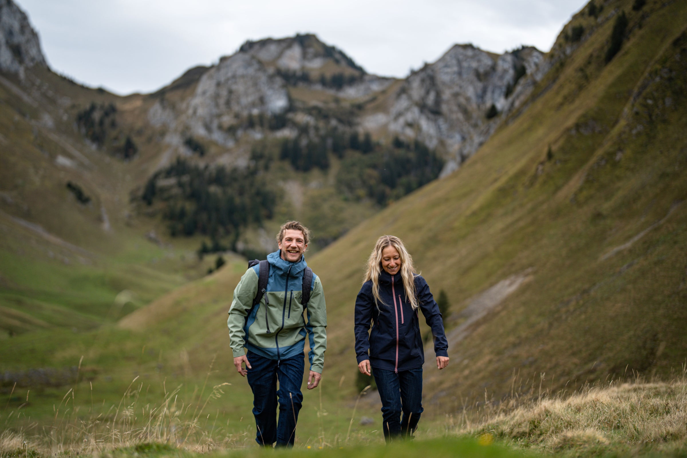 Man and woman hiking in the mountains wearing waterproof jackets