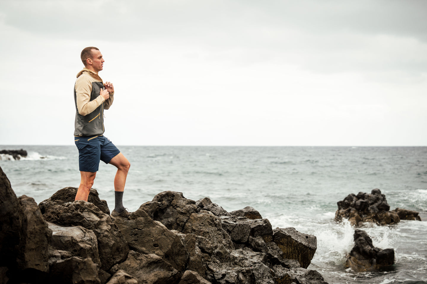 Man standing on coastal rocks wearing Natural Park shorts