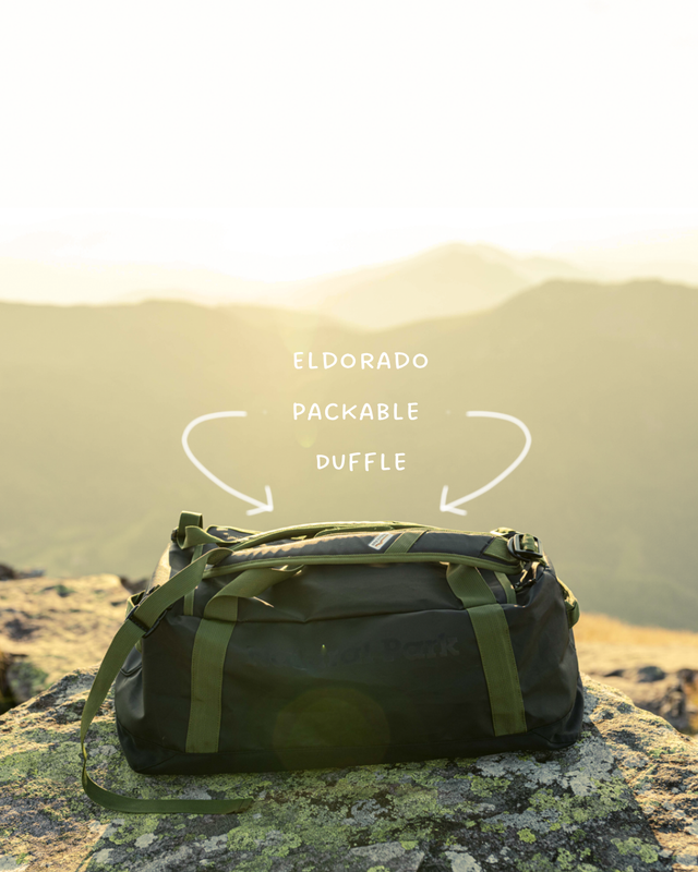 Green duffel bag on a mountain background