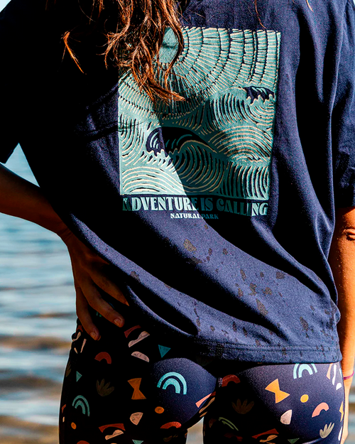 Person wearing a navy blue t-shirt with a graphic design and colourful shorts