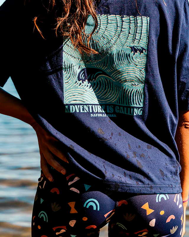 Person wearing a navy blue t-shirt with a graphic design and colourful shorts