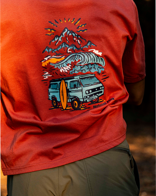 A close-up of a person wearing a red-orange graphic t-shirt