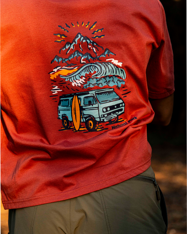 A close-up of a person wearing a red-orange graphic t-shirt