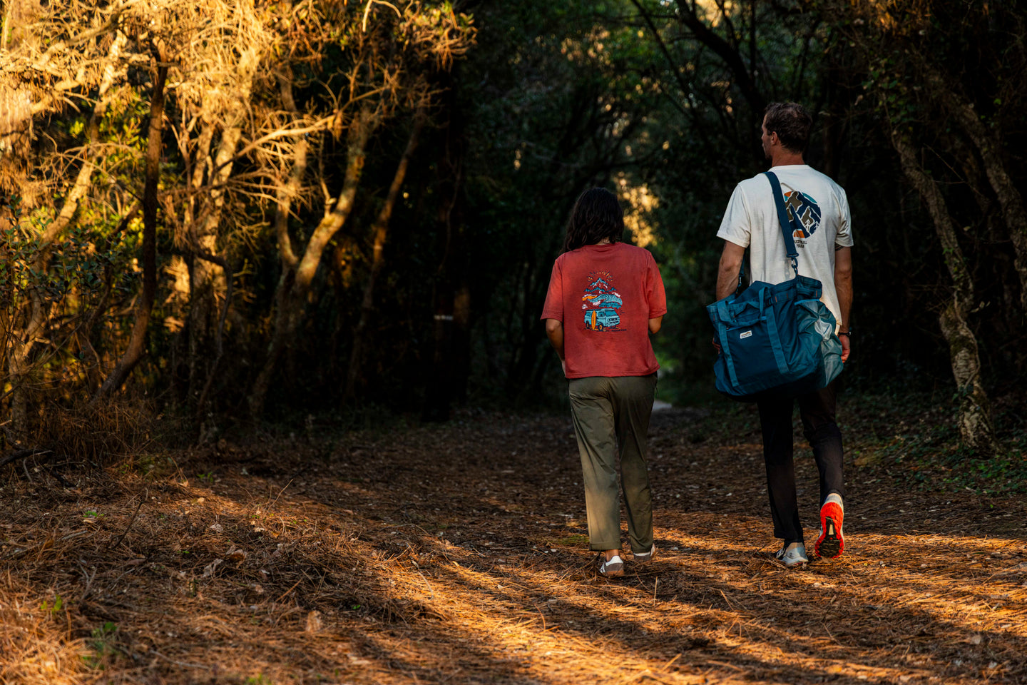 Two people walking along a forest path