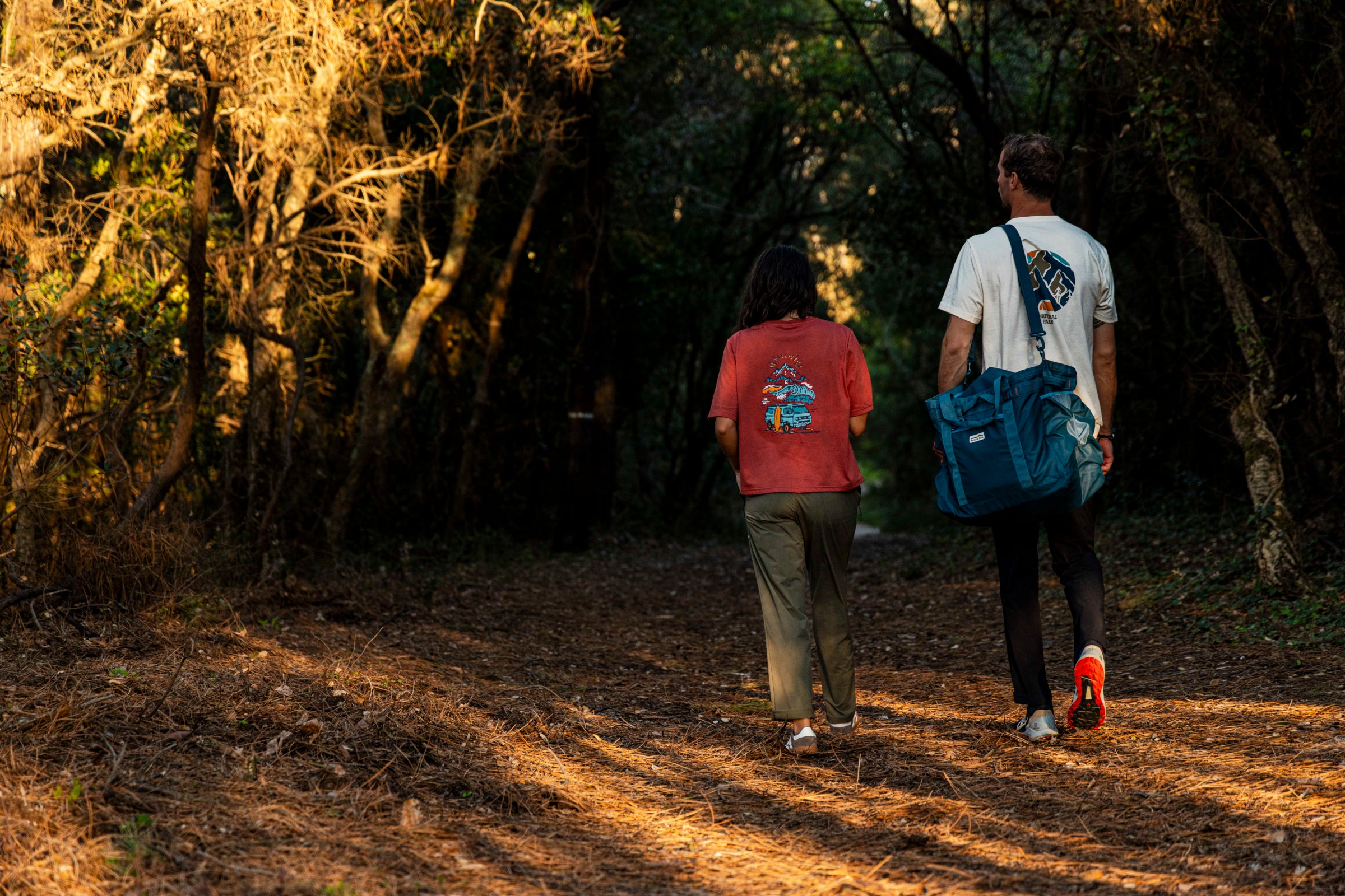 Two people walking along a forest path
